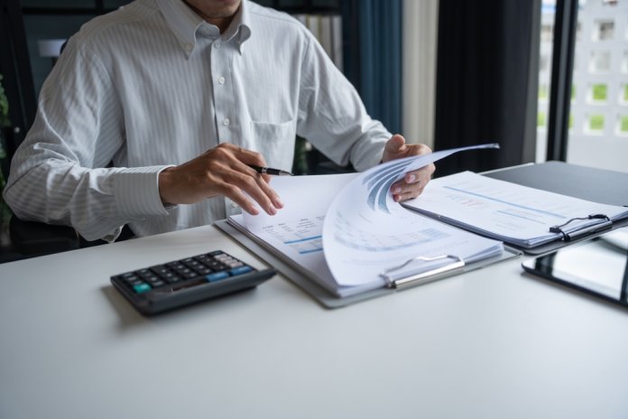 Professional,Reviewing,Business,Data,And,Using,Calculator